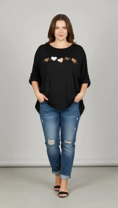 Setze ein Statement: Du trägst ein schwarzes Top mit Herzchen, coole blaue Ripped Jeans und stylishe Sandalen vor grauem Hintergrund.