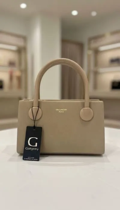 Entdecke deine neue PARISIAN Handtasche mit runden Griffen und stylishem Tag - das It-Piece für deinen modernen Look!.