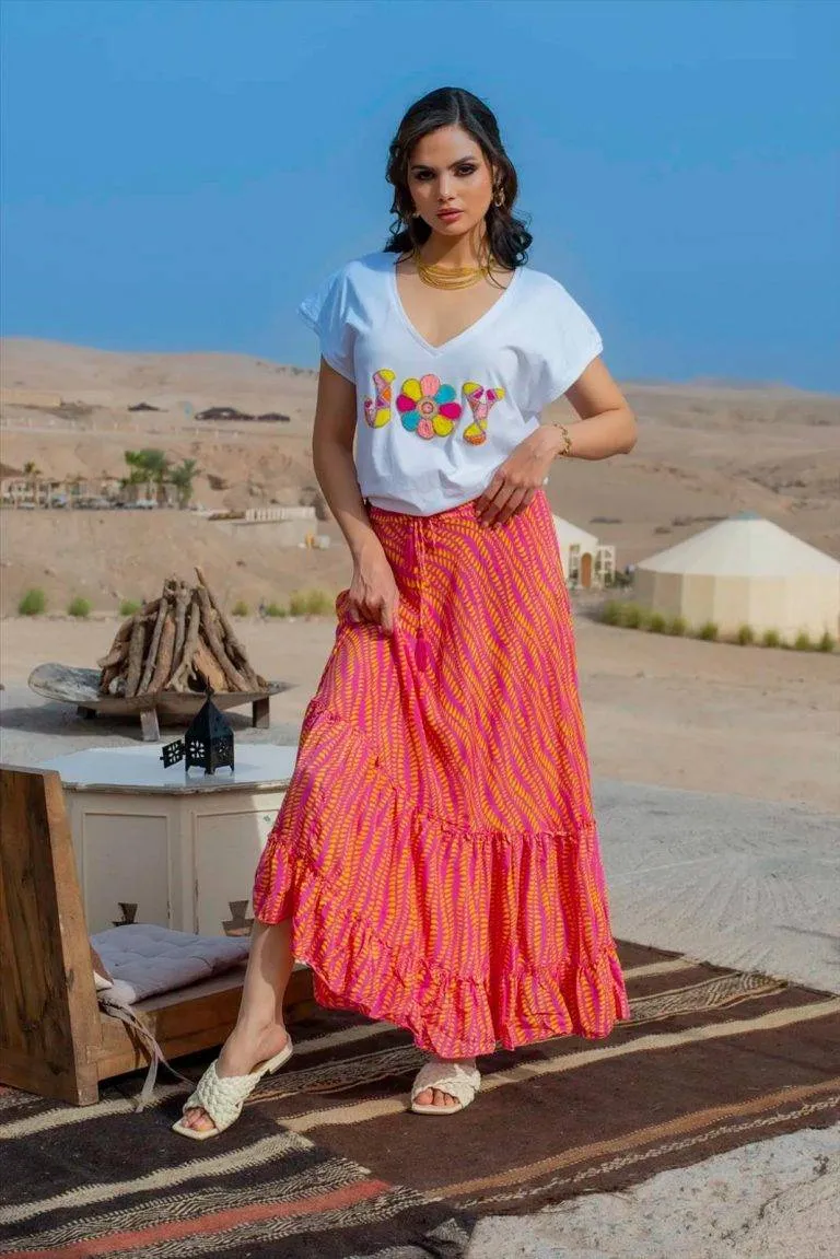 Frau in Marokko bei Sonnenuntergang. Rock mit Streifen im Wüstensand. Marokko Mode.