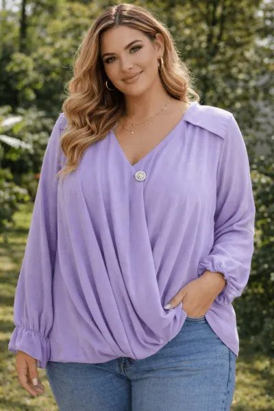 Home Chérie Bluse: Frau in lila Wickelbluse mit Jeans. Elegante Damenmode mit Knopfdetail. Trendige Oberteile online kaufen.