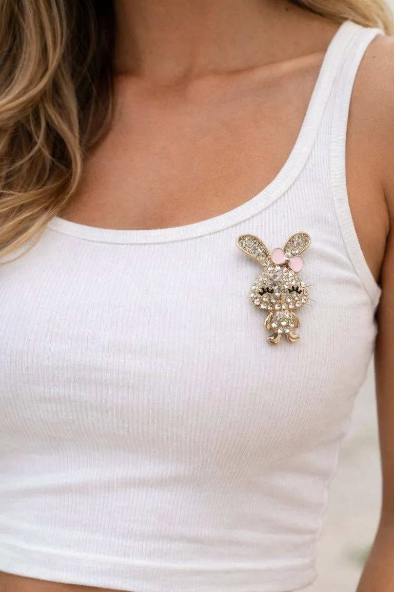 Kristall-Häschen Magnetbrosche auf weißem Top. Süße Hasenbrosche mit rosa Schleife. Modeschmuck.