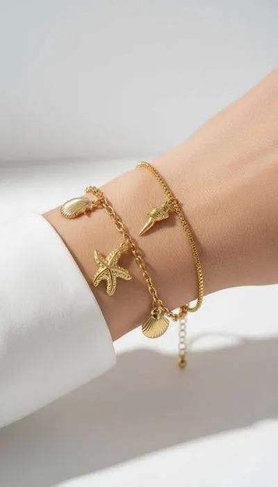 Home Goldenes Muschel Armband mit Seestern Anhänger am Handgelenk. Flexibles Armband Accessoire.