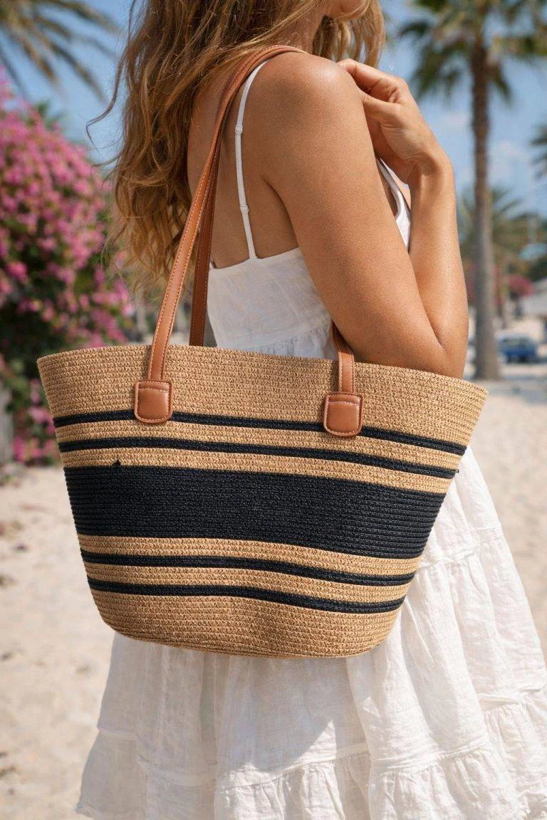 Frau in weißem Kleid am sonnigen Strand mit Amalfi Beach Bag - stilvoll, geräumig, perfekt für den Urlaub. Palmen und Blumen im Hintergrund.