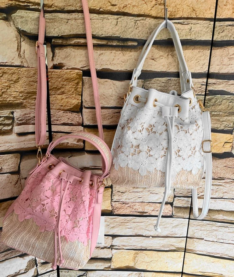 Romantik Bucket Bags in Pink und Weiß mit eleganter Spitze, sicherem Kordelzug, goldenen Akzenten und verstellbaren Trägern für stilvolle Vielseitigkeit.