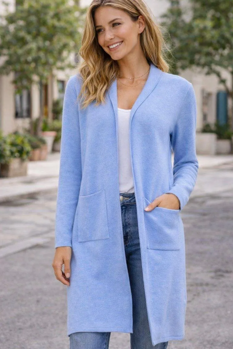 Das Model trägt den hellblauen Jessy 2.0 Cardigan, ein weiches, vielseitiges Kleidungsstück für Komfort und Stil, im Freien mit Grün.