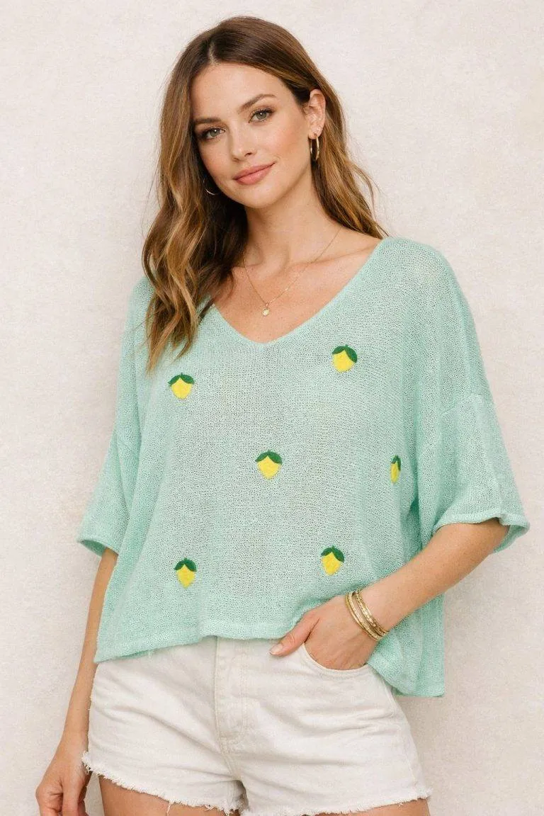 Das Model trägt einen stylischen Light Lemon Pullover mit leuchtendem gelben und grünen Muster - leicht, bequem und perfekt für den Sommer.