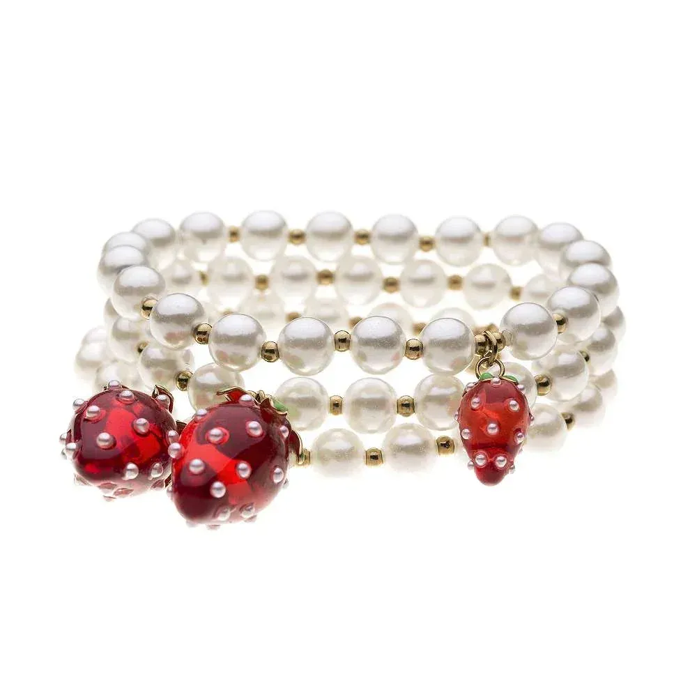 Erdbeer-Perlenarmband: Dreireihiges Armband mit weißen Perlen und roten Erdbeeranhängern. Stilvolles Schmuckstück.