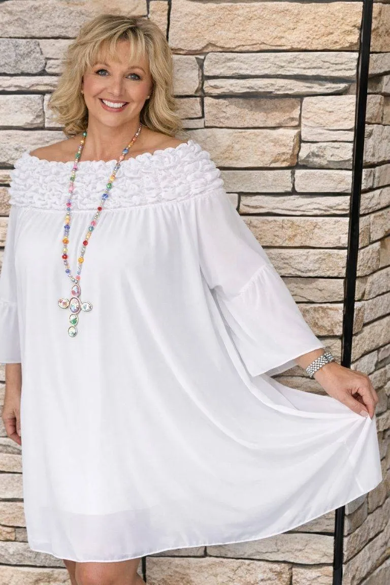 Modell trägt schickes, weißes Sophia Kleid. Elegantes Sommerkleid mit Rüschen und bunter Halskette für Damen.